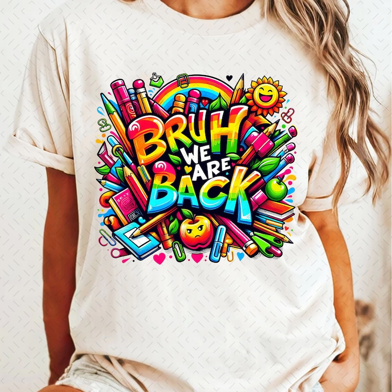 Puede incluir: Una camiseta blanca con un dise&ntilde;o gr&aacute;fico colorido que presenta el texto "Bruh We Are Back" rodeado de &uacute;tiles escolares como l&aacute;pices, crayones y una manzana.