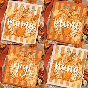 Könnte beinhalten: Ein quadratisches Dekoschild mit einer orangefarbenen Kürbisillustration, einer karierten Schleife, Herbstblättern und vertikalen Streifen. Der Schriftzug mama, mimi, gigi oder nana ist in weißer Schreibschrift auf dem Kürbis zu sehen.