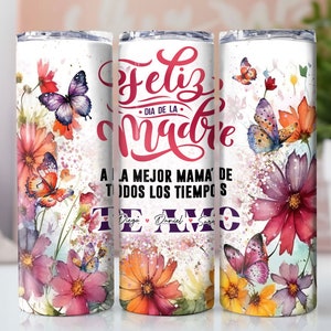 May include: White stainless steel tumbler with a floral design featuring butterflies and the text "Feliz Dia de la Madre A la Mejor Mama de Todos los Tiempos Te Amo Diego Daniel Sara".