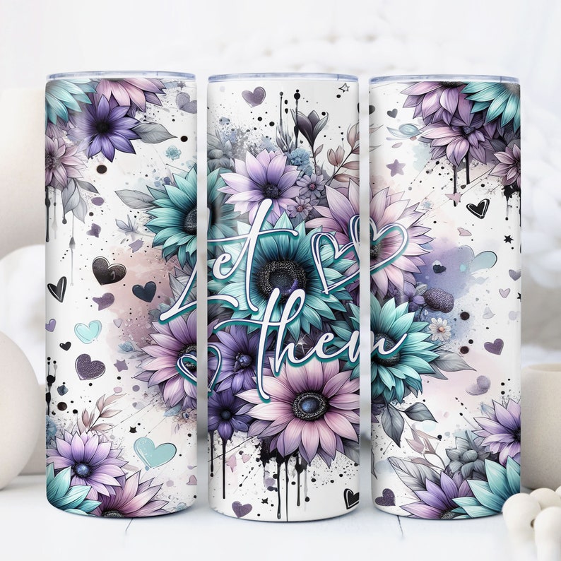 May include: White tumbler with a floral design featuring purple and teal flowers, hearts, and stars. The text "Let them" is written in a stylized font.
