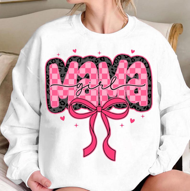 May include: White sweatshirt with a pink and black checkered design that says "Mama girl" with a pink bow.