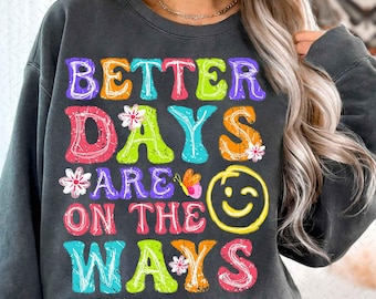 May include: A black sweatshirt with the text "Better Days Are On The Ways" in colorful letters with flowers and a smiley face.
