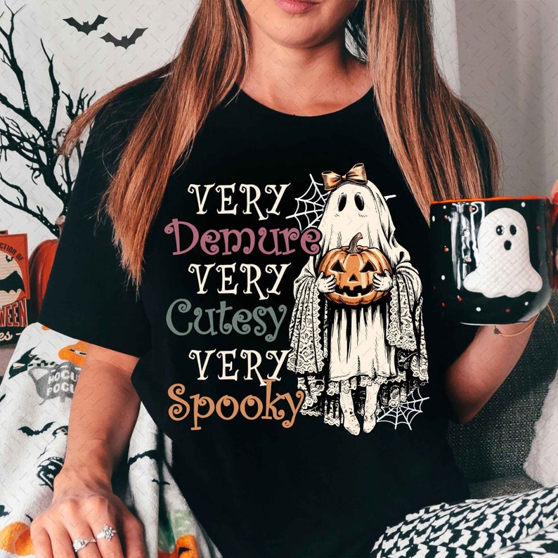 May include: Black t-shirt with a ghost holding a pumpkin and the text "Very Demure Very Cutesy Very Spooky"