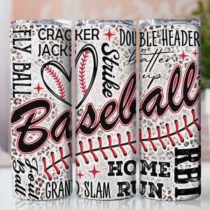 May include: White tumbler with a baseball theme. The tumbler has a leopard print background with red stitching and baseball-related words like "Fly Ball", "Strike", "Home Run", and "Grand Slam".