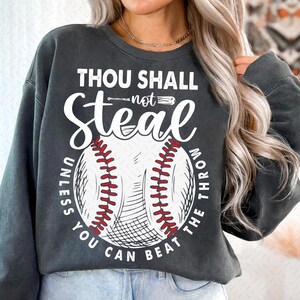 May include: A dark gray sweatshirt with the text "Thou Shall Not Steal Unless You Can Beat The Throw" and a baseball graphic.
