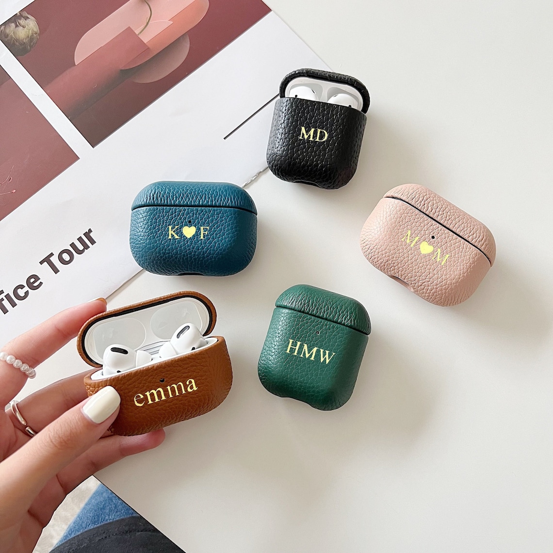 Five AirPods cases with different color leather covers on them