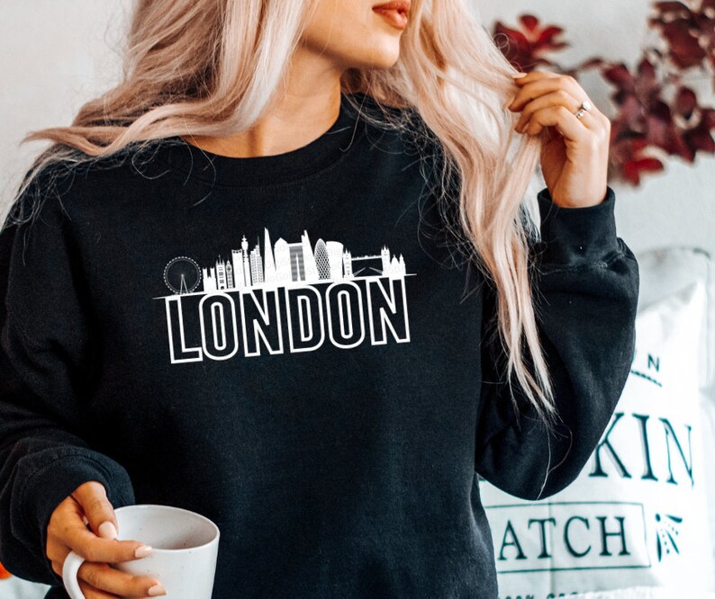 May include: Black sweatshirt with a white graphic of the London skyline and the word "LONDON" underneath.