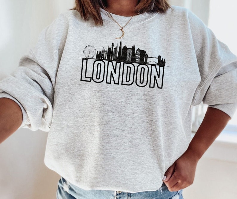 May include: Gray sweatshirt with a black graphic of the London skyline and the word "LONDON" in bold letters.