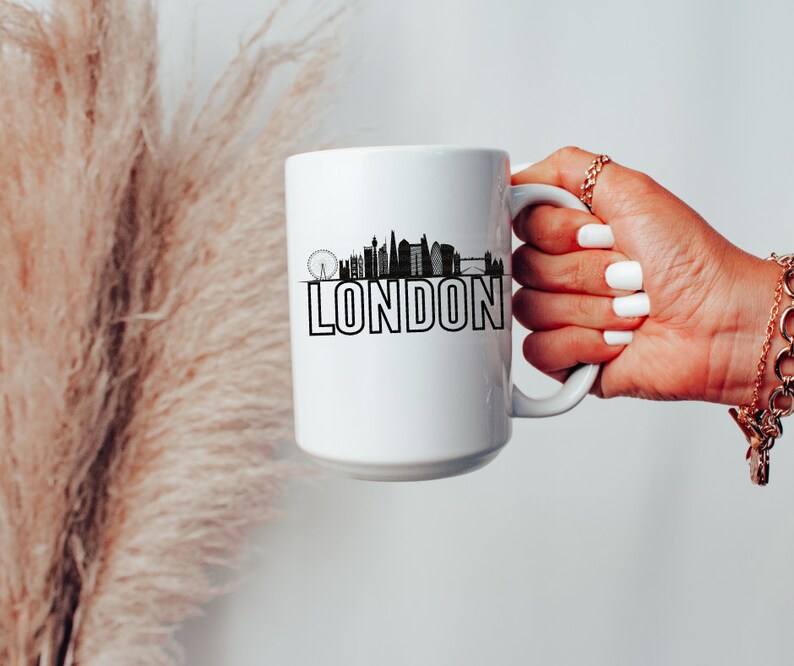 May include: White ceramic mug with a black silhouette of the London skyline and the word "LONDON" printed in black.