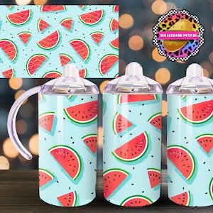 May include: Three stainless steel tumblers with a clear plastic handle and lid. The tumblers are covered in a blue and white pattern with red watermelon slices. The tumblers are on a wooden surface.