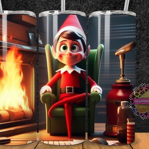 May include: A Christmas-themed tumbler featuring Buddy the Elf from the movie Elf, sitting in a green armchair in front of a fireplace. The tumbler has a red and white striped straw.