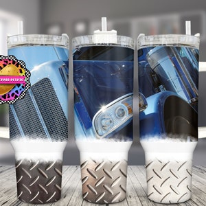 Puede incluir: Tres vasos de acero inoxidable con asa blanca y pajita. Los vasos presentan un diseño de un camión semi-remolque azul con un patrón de placa de diamante en la parte inferior.