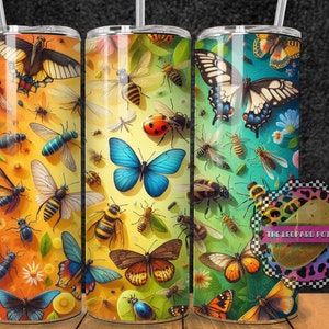 May include: Three stainless steel tumblers featuring colourful butterfly and insect designs. The tumblers have a gradient background of yellow, green, and blue. The text "THE LEOPARD POTATO" is on a sticker on the right tumbler.