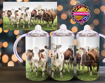 May include: Three stainless steel tumblers with lids and handles. Each tumbler features a different image of brown and white cows in a field. The text "The Leopard Potato" is printed on the lid of one tumbler.