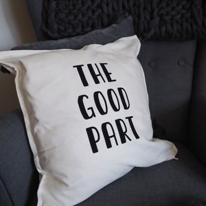 Könnte beinhalten: Ein weißes Kissen mit schwarzem Text, der "THE GOOD PART" auf einem grauen Sessel lautet.