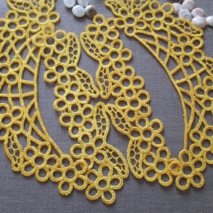 Può includere: Due motivi di pizzo all'uncinetto gialli con un design floreale. I motivi sono realizzati con delicati e intricati anelli e cerchi.