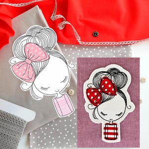 May include: Two embroidered patches featuring a cartoon girl with a bow. One has a pink bow with hearts, the other a red bow with white polka dots. Both have a white outline and a striped shirt. The background includes red fabric and gray polka dot fabric.