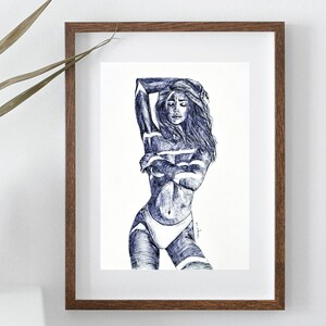 Könnte beinhalten: Gerahmte Feder- und Tuschezeichnung einer Person in sinnlicher Pose. Das Kunstwerk ist überwiegend blau und weiß, wobei die Form der Figur durch detaillierte Linien definiert wird. Die Zeichnung befindet sich vor einem weißen Hintergrund und ist in einem braunen Holzrahmen gerahmt.