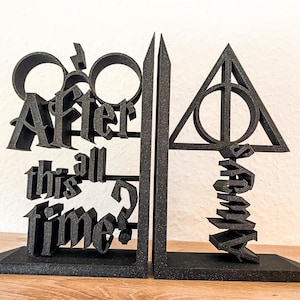 Könnte beinhalten: Schwarze Buchstützen mit dem Symbol der Heiligtümer des Todes und dem Zitat "Nach all dieser Zeit?" aus der Harry-Potter-Reihe.