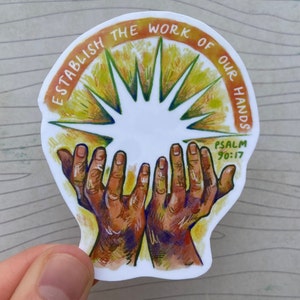 May include: A white sticker with a yellow and orange sunburst design and two hands reaching up. The text "ESTABLISH THE WORK OF OUR HANDS PSALM 90:17" is written around the sunburst.
