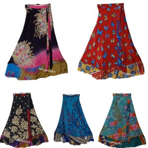May include: A collection of wrap skirts in various colors and patterns. The skirts feature floral, butterfly, and geometric designs. Colors include black, red, blue, and teal. Each skirt has a unique border and tie closure.