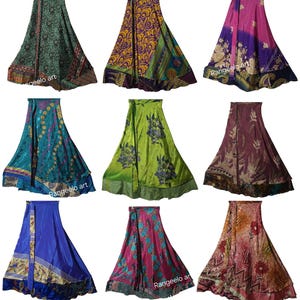 Op de afbeelding: Negen kleurrijke wikkelrokken met verschillende patronen en ontwerpen worden getoond. De rokken hebben een reeks kleuren, waaronder groen, paars, blauw en roze. Sommige rokken hebben bloempatronen, andere geometrische of abstracte ontwerpen. De rokken zijn van zijde.