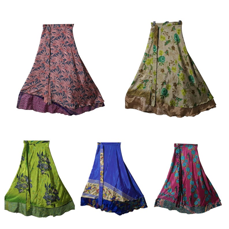 May include: Five colorful wrap skirts. The skirts feature various patterns, including floral and geometric designs. Colors include pink, green, blue, and gold. Each skirt is made of a silky material and has a flowing silhouette.