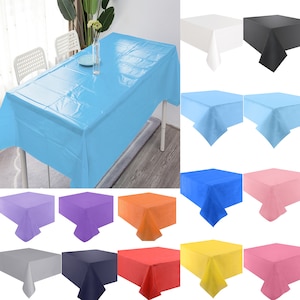 May include: A set of 10 plastic tablecloths in various colours, including white, black, light blue, blue, purple, orange, red, yellow, pink, and grey. The tablecloths are rectangular and have a smooth, shiny finish.