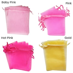 May include: Four organza bags in different colors: baby pink, pink, hot pink, and gold. The bags are made of sheer fabric and have a drawstring closure.