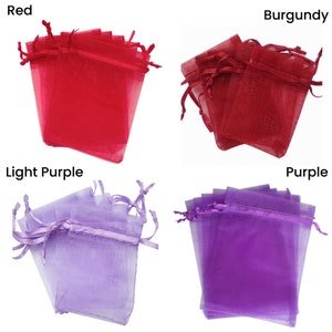 May include: Four stacks of small, sheer organza bags in four colors: red, burgundy, light purple, and purple. The bags have a drawstring closure.