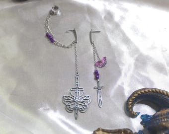 Puede incluir: Un par de pendientes de plata con un diseño de mariposa y espada. Los pendientes están adornados con cuentas moradas y un dije de mariposa rosa.