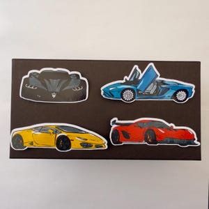 Peut inclure: Un ensemble de quatre autocollants découpés représentant des voitures de sport de luxe. La collection comprend une voiture noire vue de face avec un emblème trident, une bleue aux portes en élytre, une jaune et une rouge avec un aileron arrière.