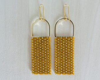 May include: A pair of gold hoop earrings with a rectangular section of yellow and gold beads hanging from each hoop.