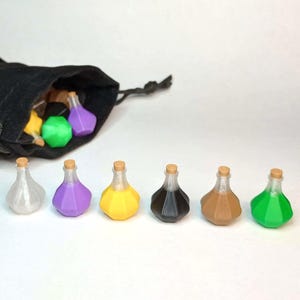May include: A black drawstring bag with several colorful potion bottles spilling out. Six potion bottles are arranged in a row, each with a cork stopper and a different colored liquid: white, purple, yellow, black, brown, and green.