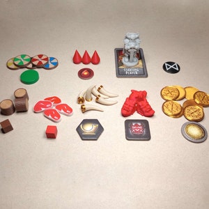 Peut inclure: Un ensemble de pièces de jeu pour un jeu de société, comprenant des bûches de bois, de la viande rouge, des boucliers rouges et blancs, des pièces d'or, des cornes rouges et blanches, un démon rouge et blanc, une statue blanche et une carte qui dit "Joueur de départ".