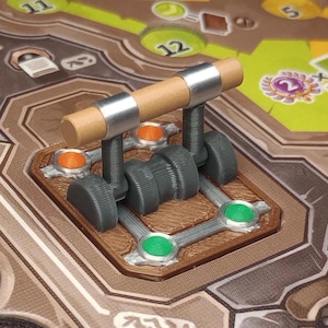 以下が含まれることがあります： 木製のレバーと金属製のギアが付いた茶色と灰色のゲームボードのクローズアップ。レバーは緑と銀の模様の金属製のベースに取り付けられています。ボードには、稲妻、王冠、いくつかの円など、さまざまなシンボルとデザインが描かれています。