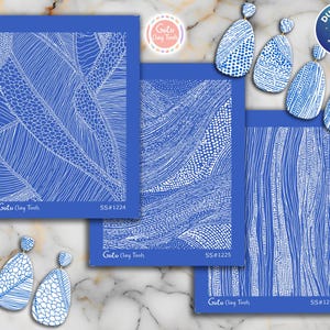 Op de afbeelding: Blauwe en witte kleigereedschappen en oorbellen. Drie blauwe rechthoekige kleigereedschappen met witte abstracte ontwerpen en de tekst "Goto Clay Tools" en "SS#1224", "SS#1225" en "SS#1226". Vier blauw-witte oorbellen.