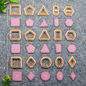 May include: A set of 15 cookie cutters in various shapes, including squares, circles, triangles, hexagons, and diamonds. The cutters are made of metal and have a gold finish. The cutters are arranged in three rows, with each row labeled "SET-1", "SET-2", and "SET-3".