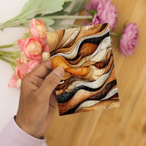 May include: A rectangular card featuring an abstract design of flowing, layered waves in shades of burnt orange, cream, and dark brown. The pattern includes intricate textures resembling scales, fine lines, and stippled dots across the surface.