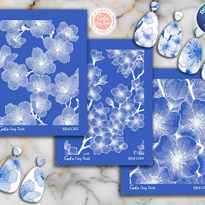 Puede incluir: Herramientas de arcilla y pendientes con diseño floral azul y blanco. Las herramientas presentan patrones florales blancos sobre un fondo azul, con el texto "Goto Clay Tools" y códigos de producto. Los pendientes tienen un diseño floral similar.