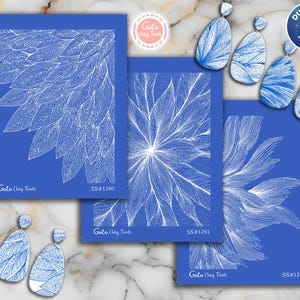 Peut inclure: Des motifs bleus pour outils d'argile avec des motifs de feuilles blanches, comprenant trois cartes rectangulaires et plusieurs paires de boucles d'oreilles assorties. Les cartes sont étiquetées "Goto Clay Tools" et "SS#1260", "SS#1261", et "SS#1262".