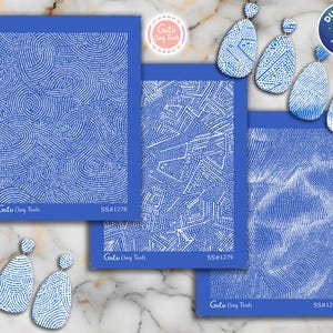 Könnte beinhalten: Drei blaue, rechteckige Tonwerkzeuge mit weißen Punktmustern, beschriftet mit SS#1278, SS#1279 und SS#1280. Die Werkzeuge weisen unterschiedliche Designs auf, darunter Wirbel, geometrische Formen und ein strukturiertes Muster. Das Bild zeigt auch passende blaue und weiße Ohrringe.