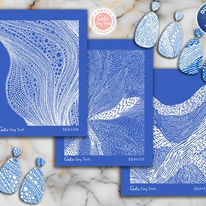 Op de afbeelding: Blauwe en witte abstracte kunstontwerpen met bijpassende oorbellen. De ontwerpen staan op blauwe kaarten met witte lijntekeningen. De oorbellen hebben een vergelijkbaar patroon. De tekst "Goto Clay Tools" en productcodes zijn zichtbaar.