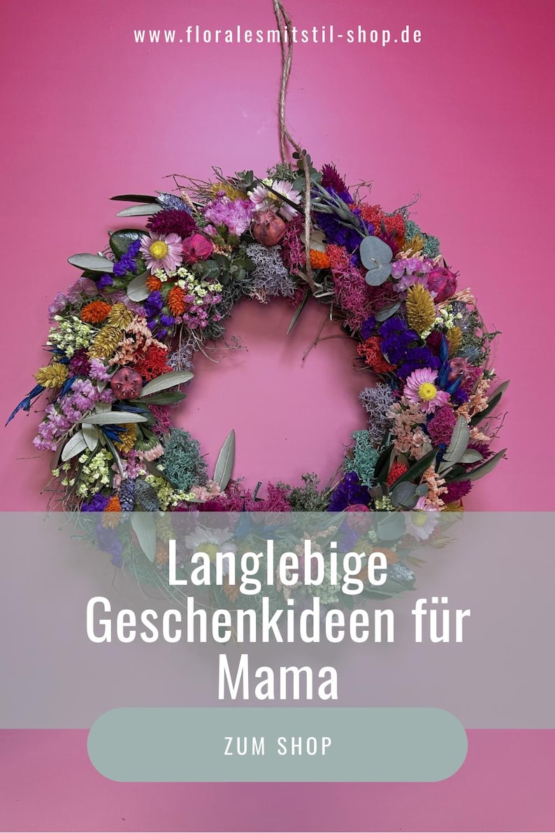 May include: A vibrant floral wreath composed of dried flowers in shades of pink, purple, yellow, and green, set against a pink backdrop. The image includes text in German: "Langlebige Geschenkideen f&uuml;r Mama".
