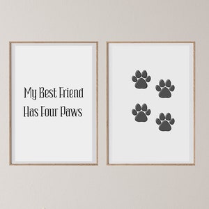 May include: Two framed prints on a white wall. The print on the left says "My Best Friend Has Four Paws". The print on the right has four black paw prints.