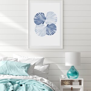 Puede incluir: Una impresi&oacute;n enmarcada de una pintura de acuarela de tres conchas azules sobre un fondo blanco.