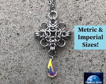 May include: A silver chain necklace with a silver metal pendant in the shape of a starburst. The pendant has a teardrop-shaped crystal hanging from it. The crystal is iridescent with yellow, blue, and green colors. The text "Metric & Imperial Sizes!" is in a blue box on the right side of the image. The text "Shimmery Moon Maille" is in a white box with a blue moon on the bottom right side of the image.