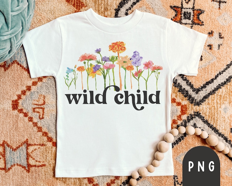 Pu&ograve; includere: T-shirt bianco con un design floreale colorato e la scritta "wild child" in nero. I fiori sono arancioni, rosa, viola e gialli. Una maglietta casual per bambini.