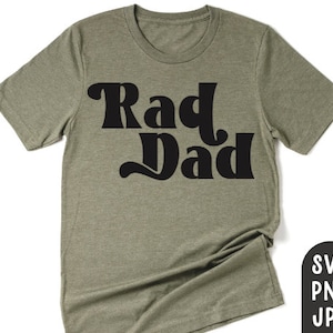 Może przedstawiać: Oliwkowa koszulka z napisem "Rad Dad" w pogrubionej, czarnej czcionce w stylu retro. Koszulka ma okrągły dekolt i krótkie rękawy. W prawym dolnym rogu znajdują się ikony typów plików: SVG, PNG i JPG.
