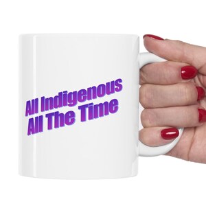 Könnte beinhalten: Eine weiße Keramiktasse mit einem lila und blauen Farbverlauf, auf der "All Indigenous All The Time" steht.
